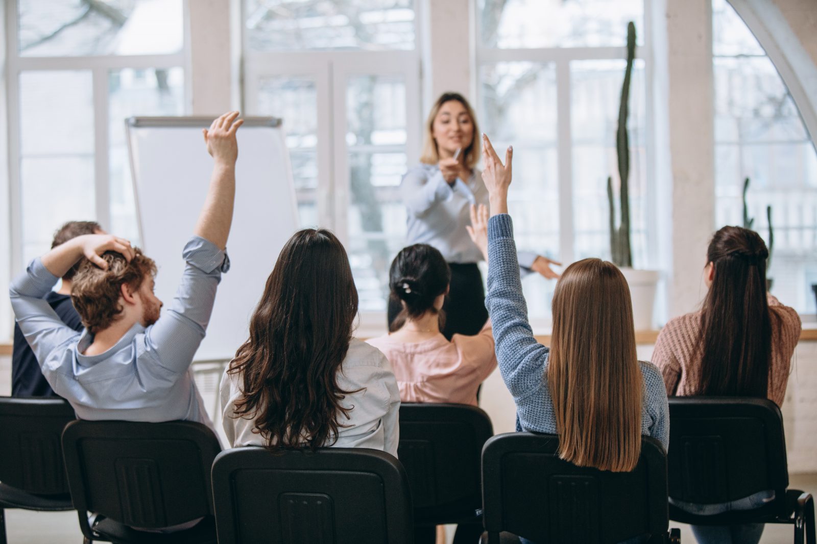 female-speaker-giving-presentation-in-hall-at-university-workshop-audience-or-conference-hall.jpg